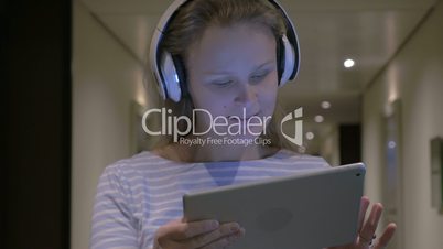 Woman in Headphondes Singing and Dancing with Tablet