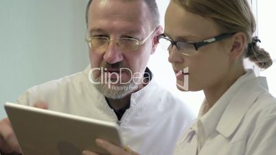 Male and female doctors discussing some issue using tablet PC