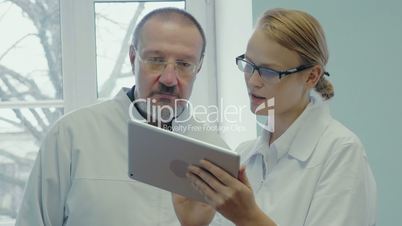 Two doctors having professional talk using touch pad