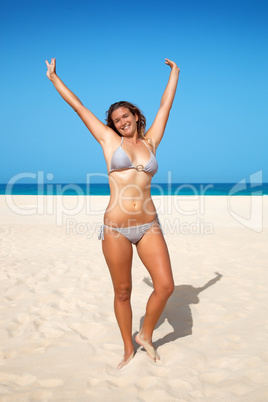 woman raised her hands up on the beach