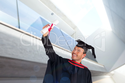 Composite image of happy attractive boy celebrating his graduati