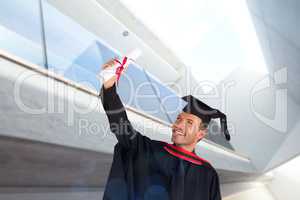 Composite image of happy attractive boy celebrating his graduati
