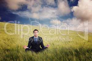 Composite image of calm businessman sitting in lotus pose