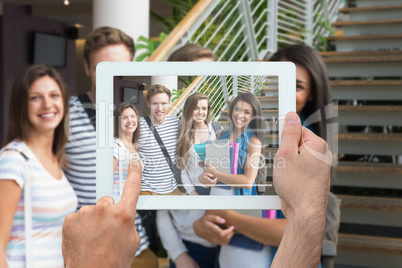 Composite image of hand holding tablet pc