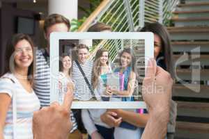 Composite image of hand holding tablet pc