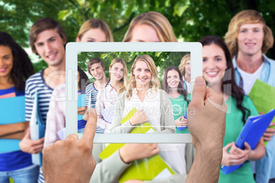 Composite image of hand holding tablet pc