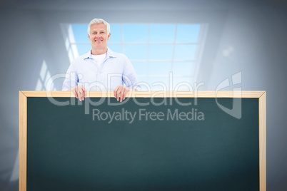 Composite image of portrait of a mature man standing behind blan