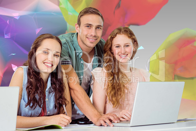 Composite image of fashion students using laptop