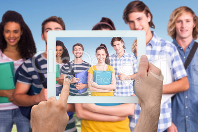 Composite image of hand holding tablet pc