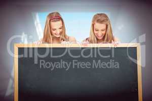 Composite image of close up of two young women holding a blank b