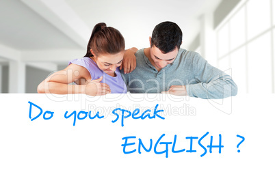 Composite image of young couple looking down a wall