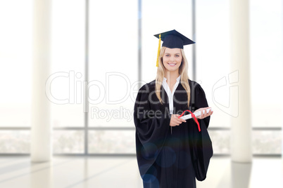 Composite image of smiling blonde student in graduate robe holdi