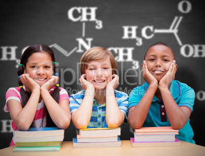 Composite image of cute pupils looking at camera in library