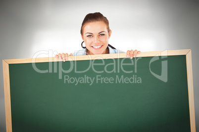 Composite image of smiling businesswoman looking over wall