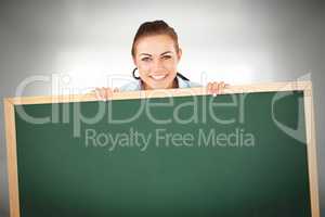 Composite image of smiling businesswoman looking over wall