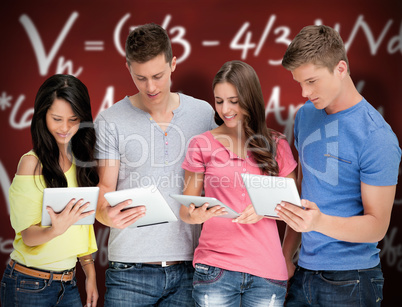 Composite image of four friends looking at their tablets and smi