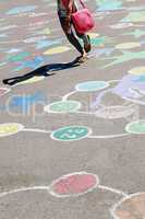 child jumping on the childish drawings on the asphalt