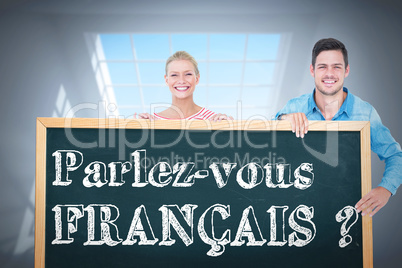 Composite image of happy man and woman pointing to card