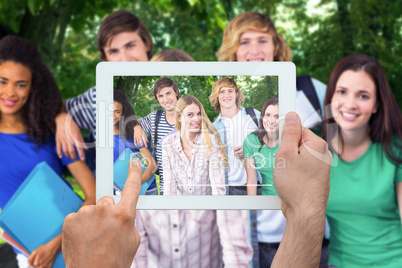 Composite image of hand holding tablet pc