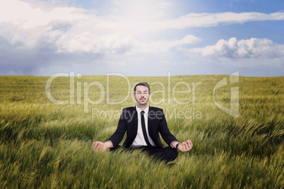 Composite image of peaceful businessman sitting in lotus pose re