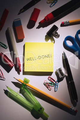 Well-done! against students table with school supplies