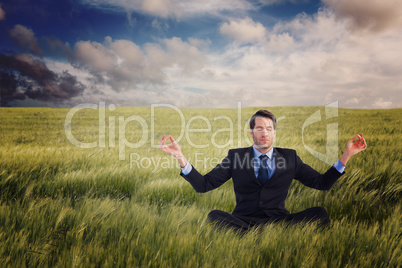 Composite image of calm businessman sitting in lotus pose