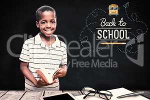 Composite image of happy pupil with book