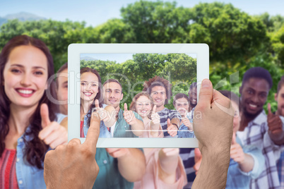 Composite image of hand holding tablet pc