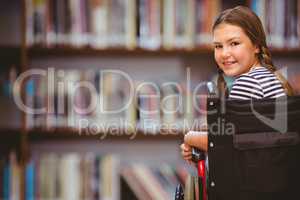 Composite image of girl sitting in wheelchair in school