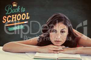 Composite image of frowning student head on her books
