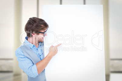 Composite image of smiling handsome man pointing at billboard