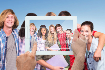 Composite image of hand holding tablet pc