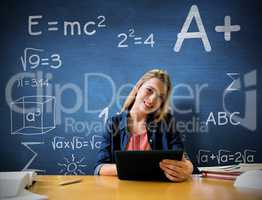 Composite image of student studying in the library with tablet