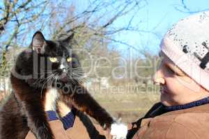 woman looking at black cat