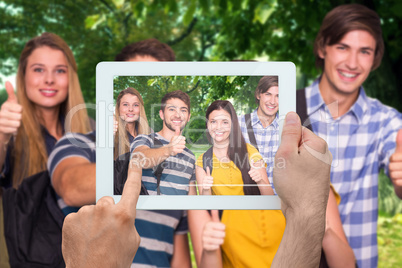 Composite image of hand holding tablet pc