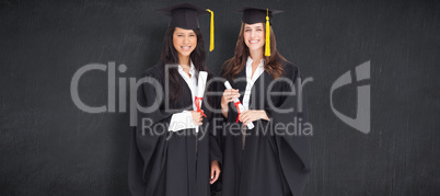 Composite image of full length shot of two women graduating