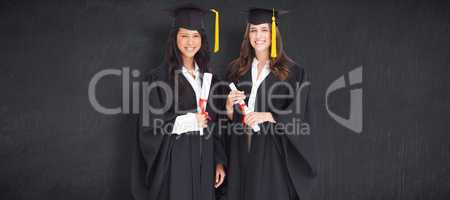 Composite image of full length shot of two women graduating