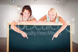 Composite image of man and cute woman pointing on a whiteboard