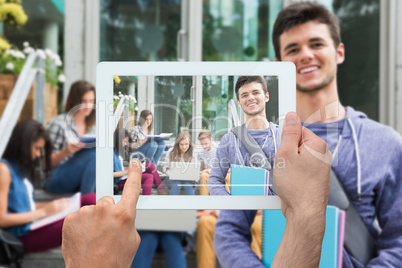 Composite image of hand holding tablet pc