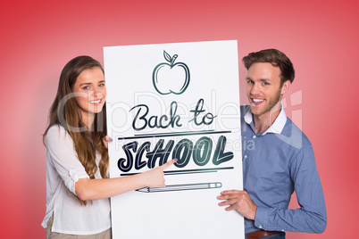 Composite image of happy young couple with blank board