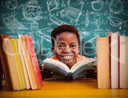 Composite image of cute boy reading book in library