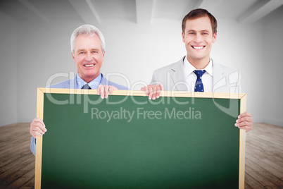 Composite image of smiling tradesmen holding blank sign