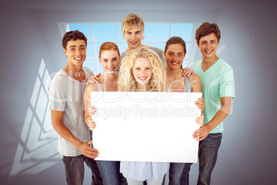 Composite image of group of teenagers holding a blank card