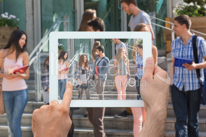 Composite image of hand holding tablet pc