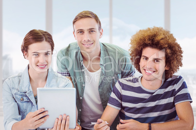 Composite image of fashion students using tablet