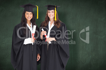 Composite image of full length shot of two women graduating