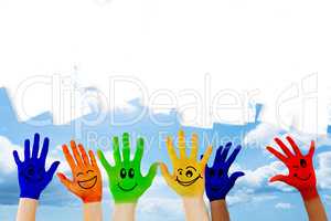 Composite image of hands with colourful smiley faces