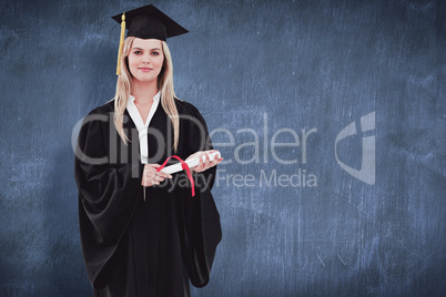 Composite image of blonde student in graduate robe holding her d