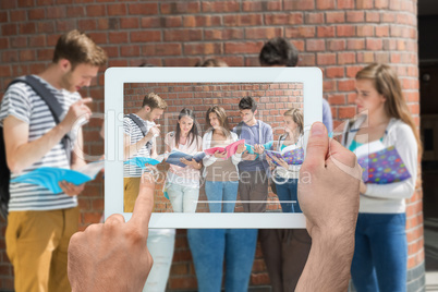 Composite image of hand holding tablet pc