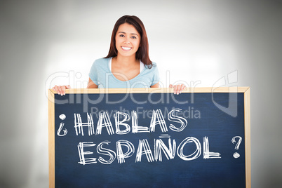 Composite image of attractive woman holding a  board